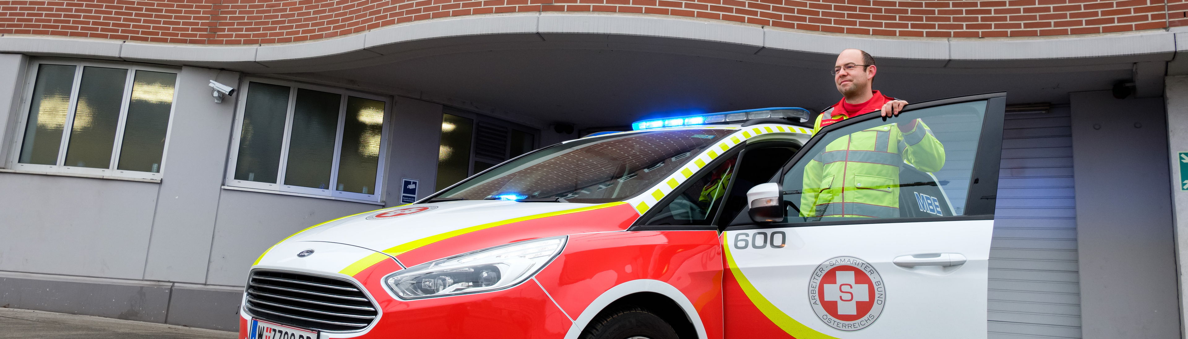 Mobile Betreuung und Entwicklung Auto mit offener Türe und stehendem Fahrer vor dem Auto