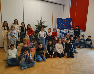 Die LernLEO Kids freuen sich über ihre Weihnachtsgeschenke und posieren in der Gruppe fürs Foto.