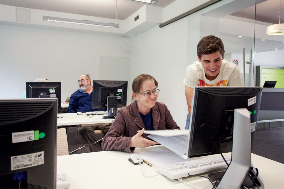 Internetcafé Zwischenschritt - Mitarbeiter hilft Klientin am PC