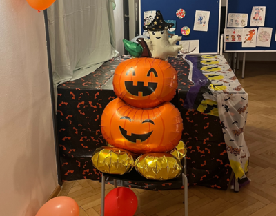 Bei der Lernleo Halloween party liegen zwei Halloween-Kürbisballons liegen aufgestapelt und auf einem Stuhl 