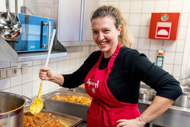 Ehrenamtliche Samariter Suppenopf Helferin rührt das Essen mit einem großen Kochlöffel um