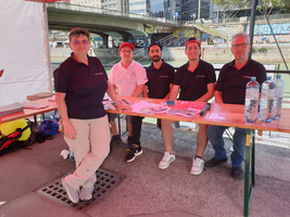 Ehrenamtliche Mitarbeiter:innen am World Drowning Prevention Day bei Infotisch am Donaukanal, 5 Personen, davon 1 Frau, tragen blaue bzw. ein weißes Samariterbund T-Shirt