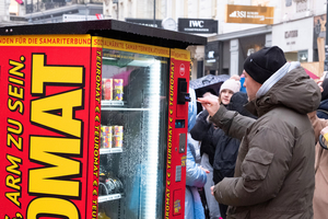 Person kauft Produkt beim Teuromaten am Graben 