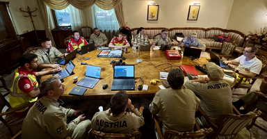 Eine Gruppe von Personen arbeitet an Laptops an einem Konferenztisch.