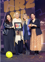 Gruppenfoto vier Personen stehen auf Bühne bei den Effie Awards, halten Awards in der Hand und lächeln in Kamera