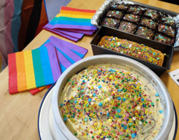 Bunter Streuselkuchen auf einem Tisch, daneben liegen Regenbogenfahnen, Brownies