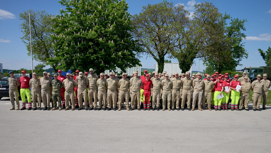 Gruppenfoto von etwa 50 Einsatzkräften in Arbeitskleidung im Freien.