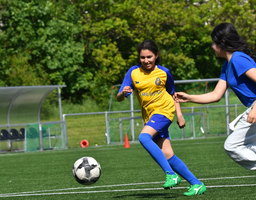 Zwei Mädchen in gelb-blauem Trikot spielen Fußball