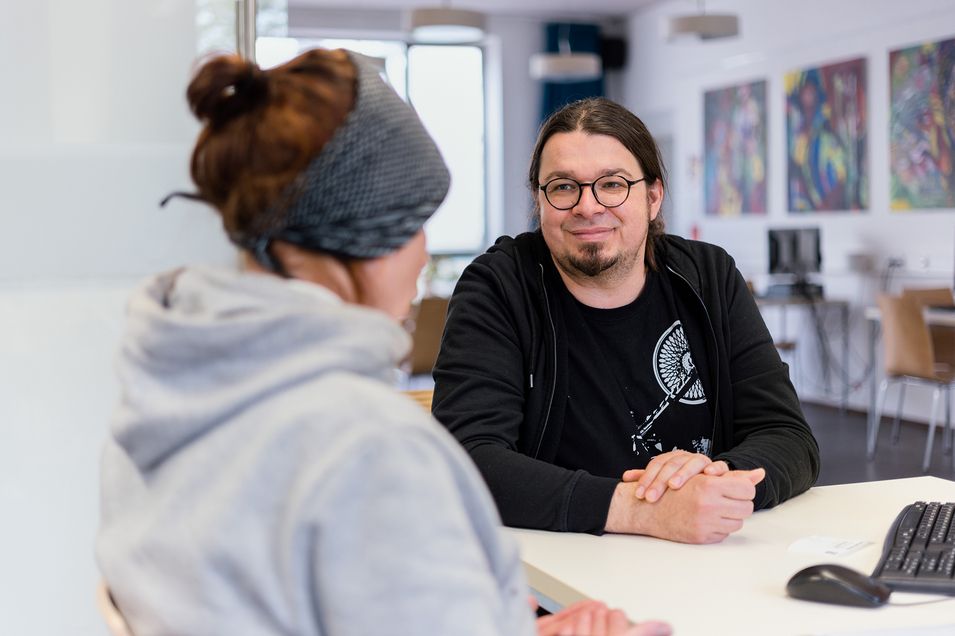 Internetcafé Zwischenschritt - Mitarbeiter sitzt bei Klientin