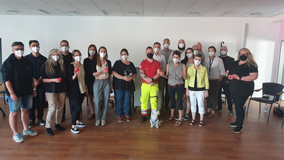 Gruppenbild Abteilungsleiter:innen Samariterbund Wien nach Workshop, manche in Uniform, manche in blauen Polos, manche in Straßenkleidung, tragen alle FFP2-Maske