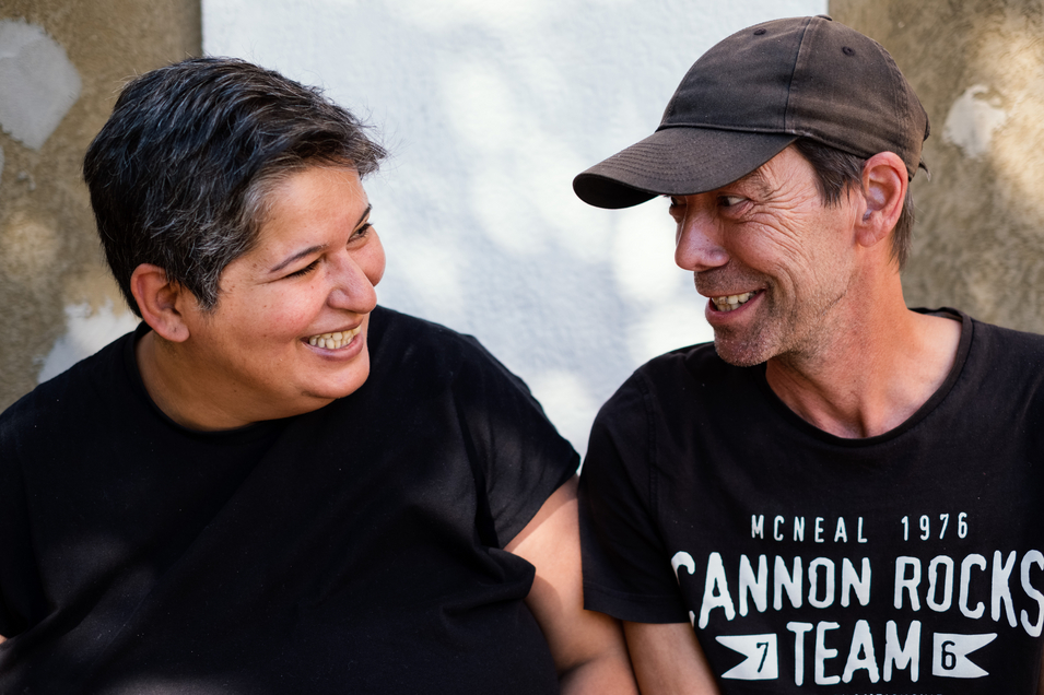 Eine Bewohnerin und ein Bewohner sehen sich an und lachen