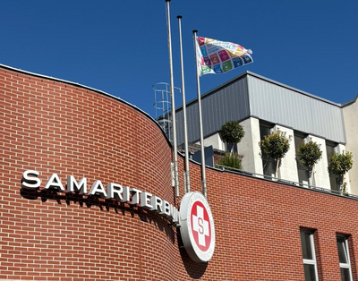 Die SDG Flagge auf dem Samariterbund-Gebäude bei strahlend blauem Himmel.