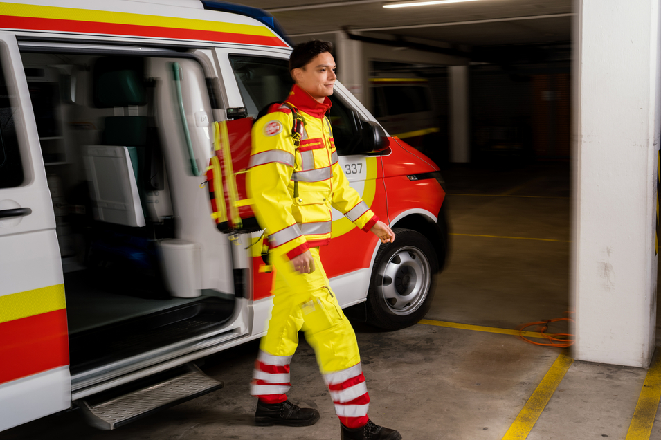 Zivildiener mit Rucksack steigt aus Rettungswagen aus
