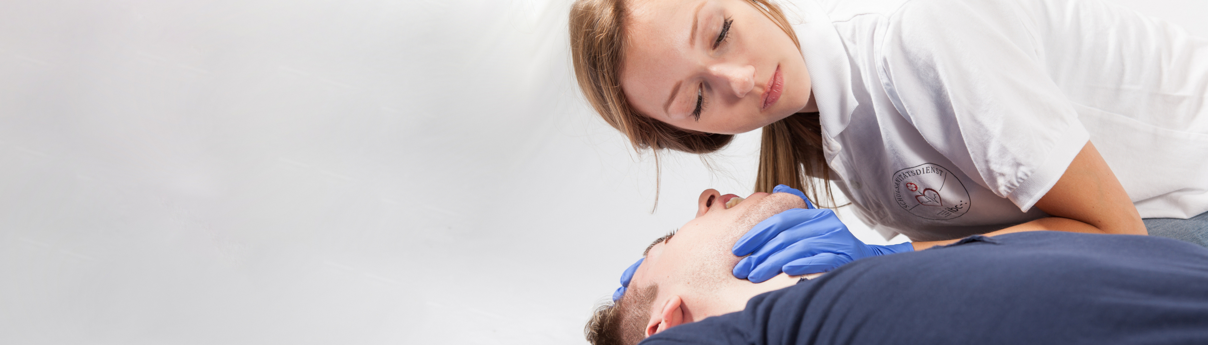 Schulsanitäterin überprüft Atmung bei einem Patienten 