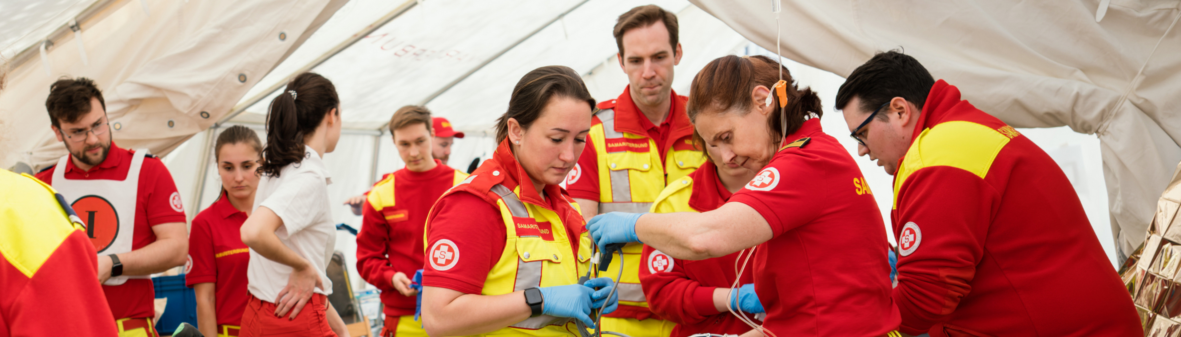 Team von Rettungssanitäter:innen in einem Zelt bereitet alles für Einsatz bei Veranstaltung vor