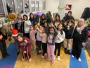 Eine Gruppe von Kindern und Erwachsenen posiert fröhlich für ein Foto.