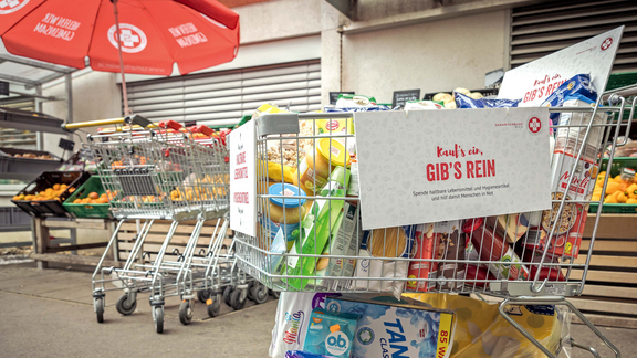 Volles Samariterwagerl im Sozialmarkt mit einer Aufschrift Kauf's ein gibs's rein.