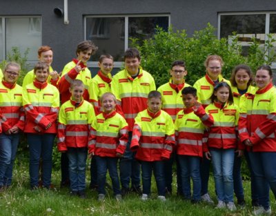 Gruppe von Kindern und Erwachsenen in Einsatzuniform