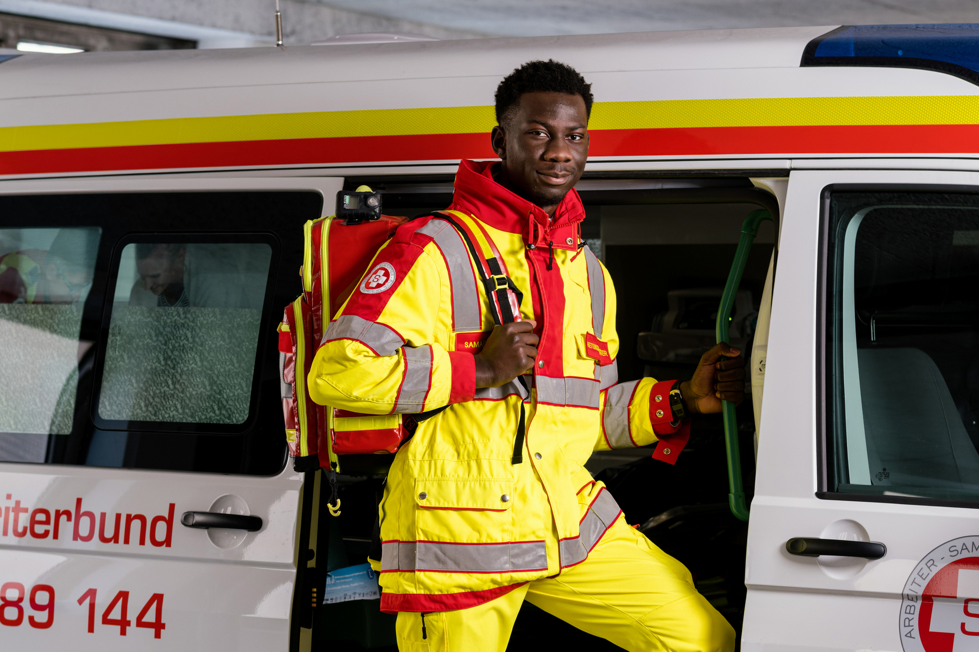 Zivildiener mit Rucksack steigt in Rettungswagen