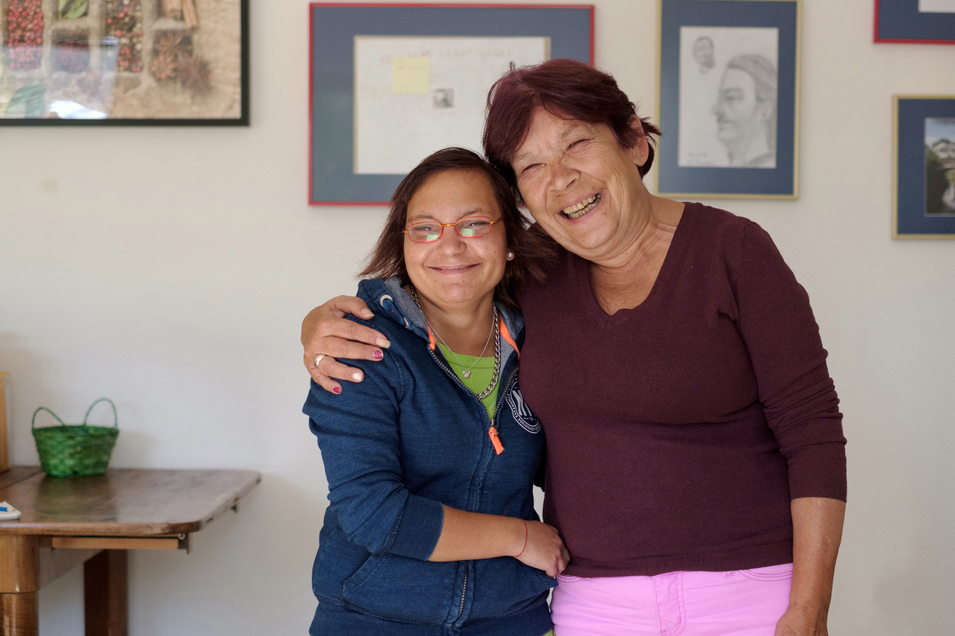 Wohnungslosenhilfe - zwei Bewohnerinnen umarmen sich in Gemeinschaftsraum