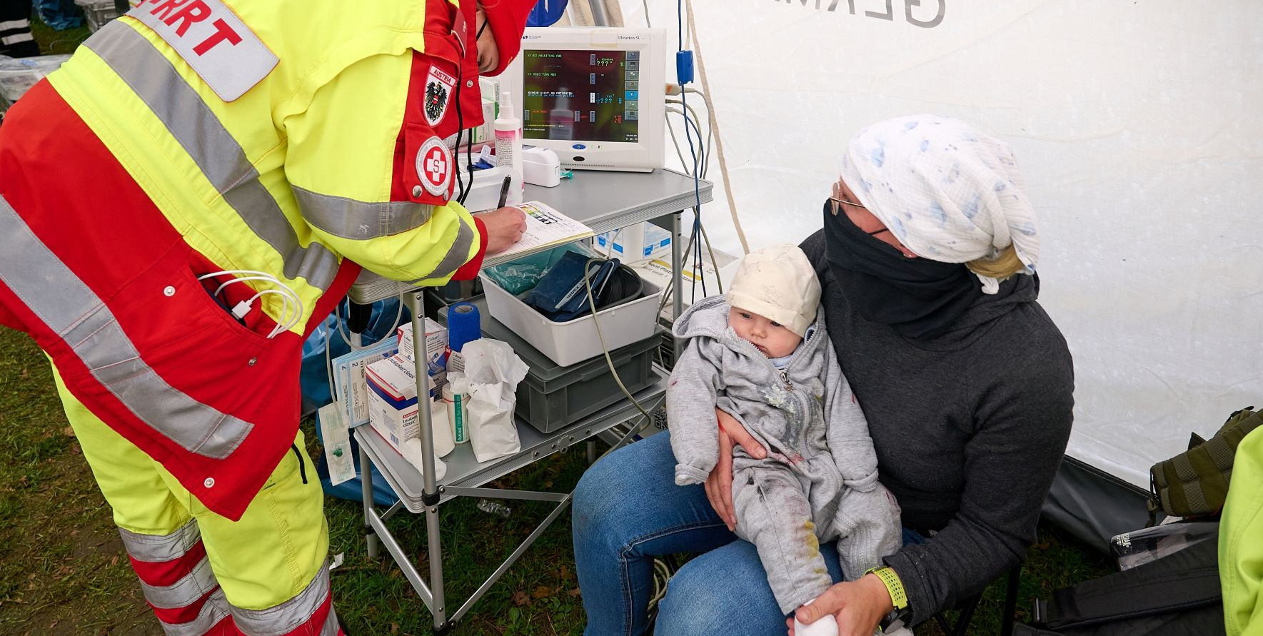 Emergency Medical Team (EMT) betreut Mutter mit Kind
