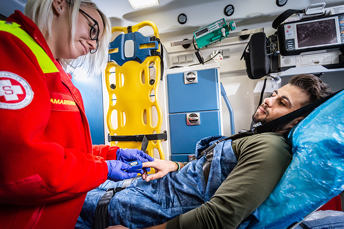 Ehrenamtliche Sanitäterin sitz im Rettungswagen neben Patient