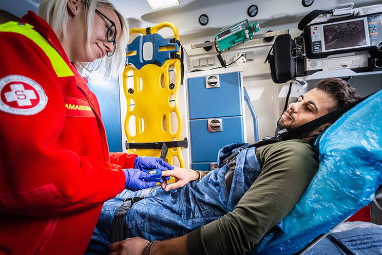 Rettungssanitäterin misst Sauerstoffsättigung bei Patient im Rettungswagen