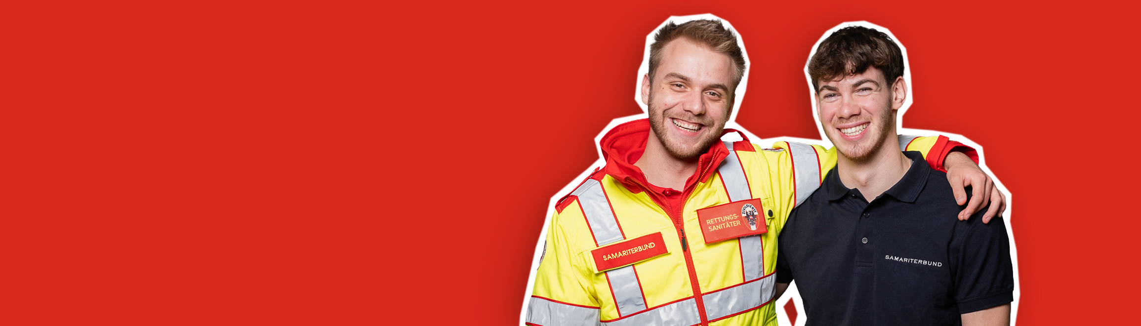 Zwei lächelnde Männer stehen nebeneinander; einer trägt eine Sicherheitsjacke.