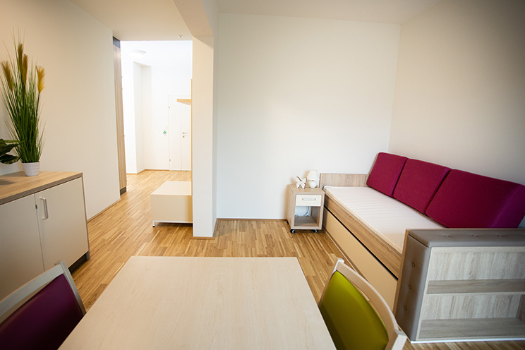 Senioren WG-Helene-Thimig-Weg Einzelzimmer mit Bett, Tisch und Sideboard