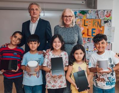 Gruppenbild zwei Erwachsene mit Kindern, technische Geräte in der Hand