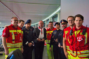 Gruppe von Rettungskräften und Polizisten stehen neben Minister Kraner.