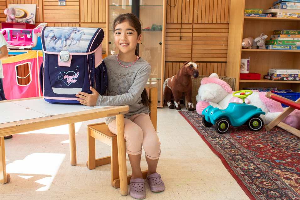 Mädchen präsentiert stolz ihre neue Schultasche