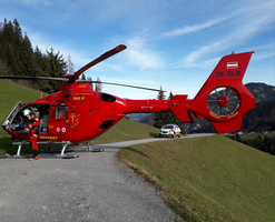 Rettungshubschrauber auf einem Weg mit einem Sanitäter in der Nähe.