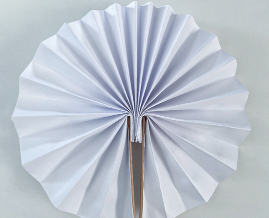 Weißer aus Papier gefalteter Fächer