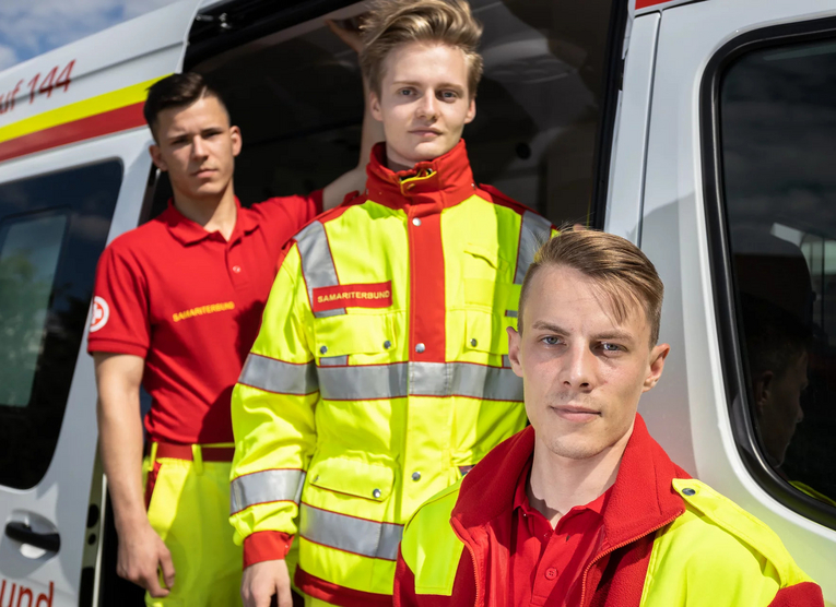 3 Sanitäter vor Rettungsauto