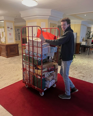 Ein Mitarbeiter bringt Geschenke auf einem Paketwagen ins Hotel de France.