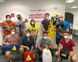 Gruppenbild Trainer:innen Ausbildungszentrum Wien, alle tragen FFP2-Maske, halten unterschiedliche Rettungseinsatzgeräte in der Hand