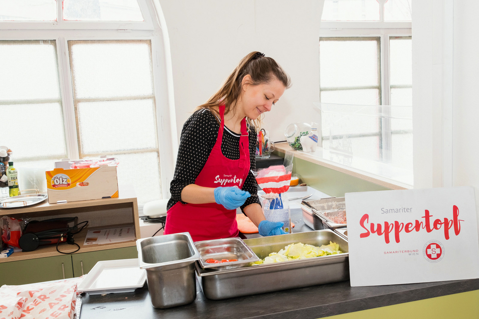 Samariter Suppentopf - Ehrenamtliche Mitarbeiterin verteilt Essen