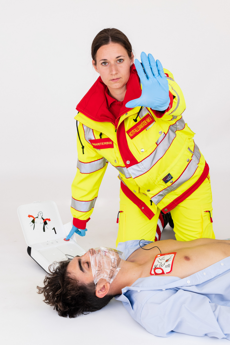 Sanitäterin wendet Defibrillator an Patienten an