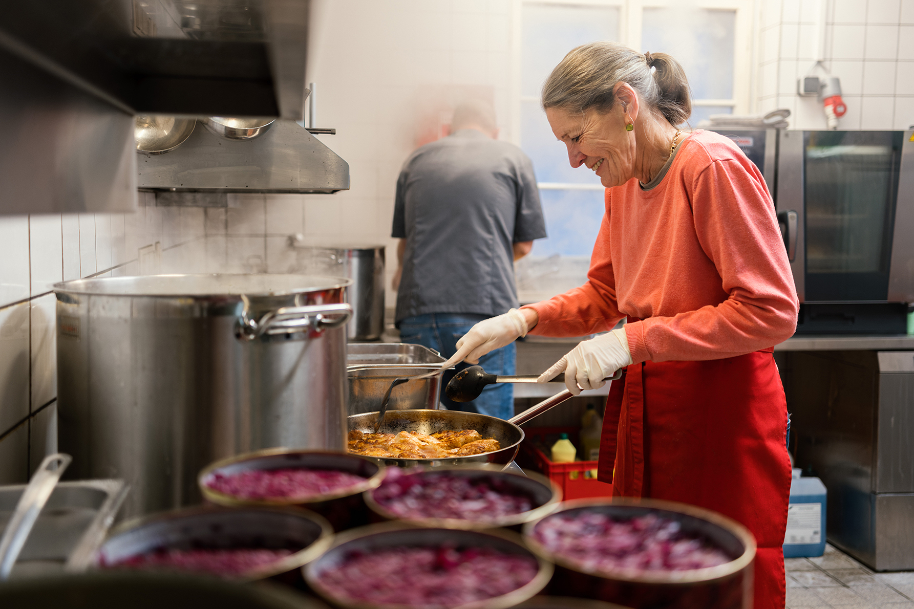 Ehrenamtliche Mitarbeiterin kocht für Samariter Suppentopf in Gastro-Küche