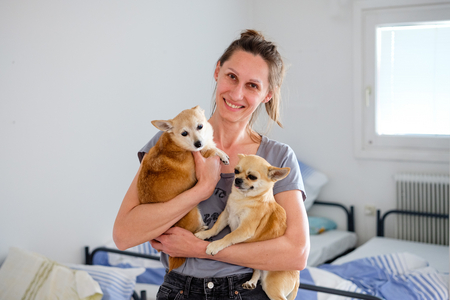 Frau in Schutzeinrichtung mit ihren zwei kleinen Hunden