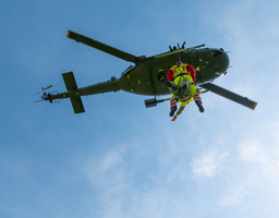 Zwei Personen seilen sich von einem Hubschrauber ab.