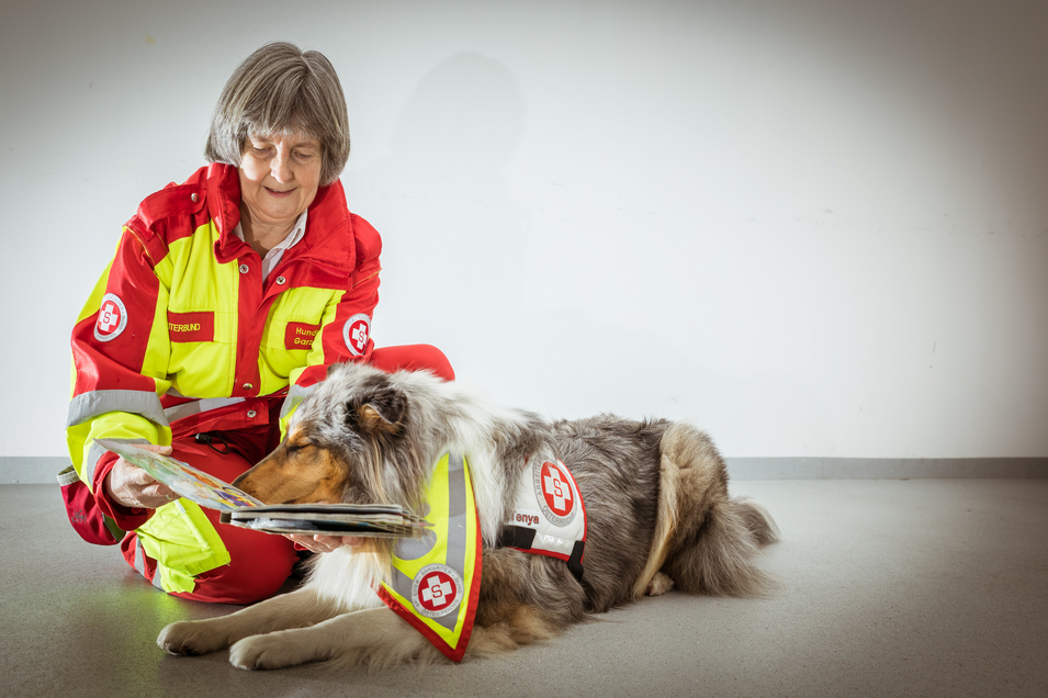 Therapiehund mit Trainerin und Buch