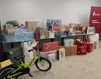 Viele bunt verpackte Geschenke und ein Fahrrad stehen beisammen.