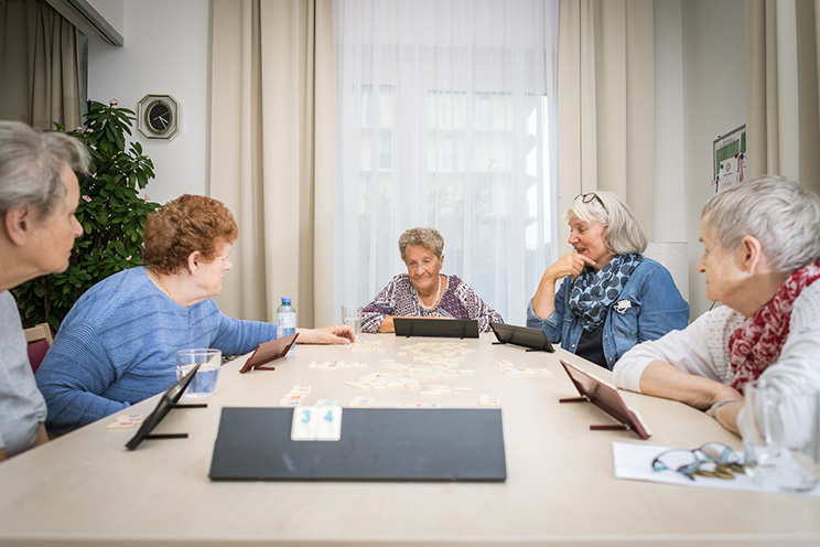 Senioren WG-Helene-Thimig-Weg Bewohnerinnen sitzen im Gemeinschaftsraum bei Gesellschaftsspielen