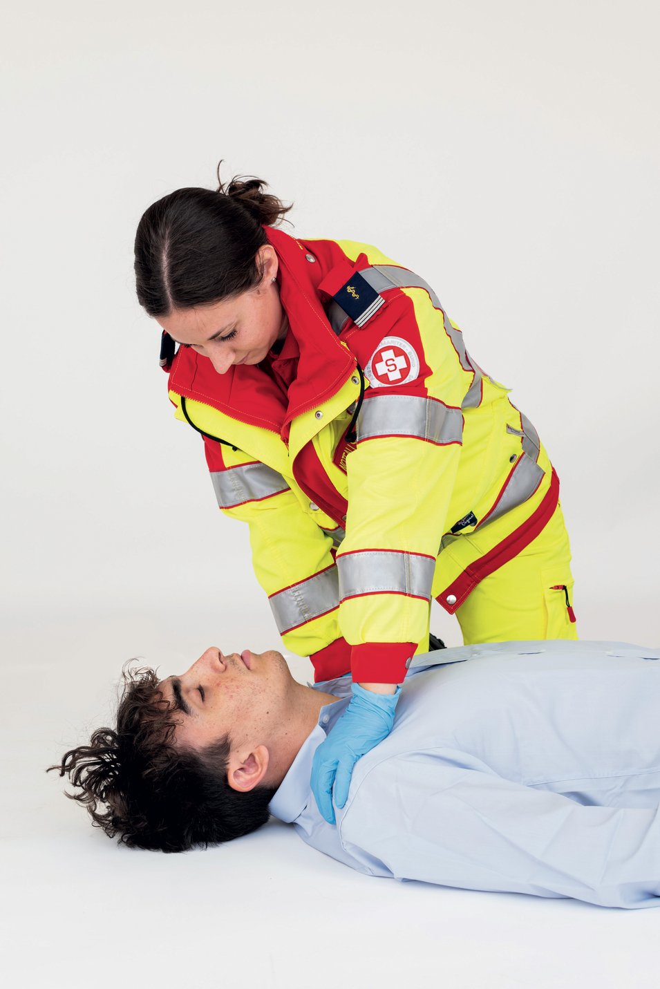 Sanitäterin bringt Patient in Position für Schocks mit dem Defibrillator
