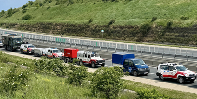 Rettungsfahrzeuge und Lieferwagen stehen auf einer Autobahn.