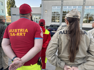 Gruppe von Einsatzkräften mit Ausrüstung, die den Rücken zur Kamera gedreht haben.